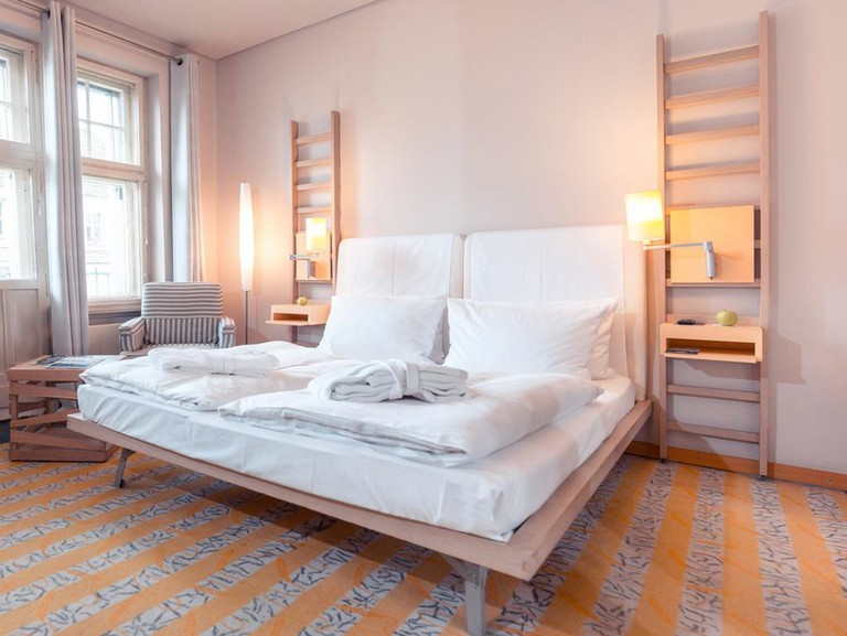 A modern bedroom at the Hotel Bleibtreu Berlin by Golden Tulip with a Scandi-style furniture and a large double bed