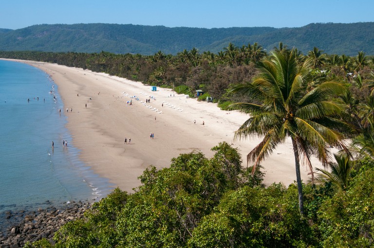 The sandy beach, blue sea and many trees at Four Mile Beach at Port Douglas