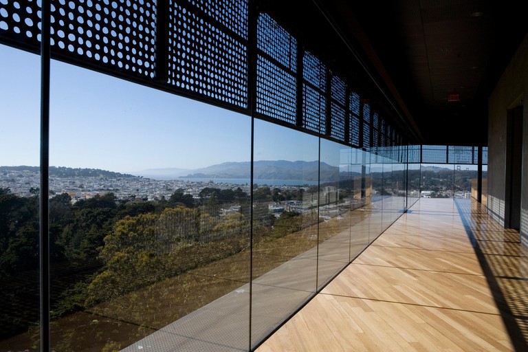 The floor-to-ceiling glass windows of the de Young Museum in San Francisco, with views onto Golden Gate Park
