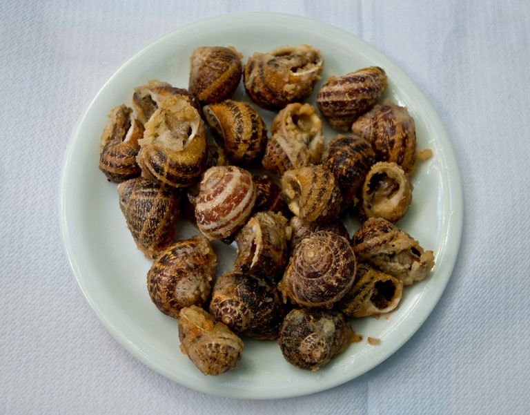 Fried snails on a white plate